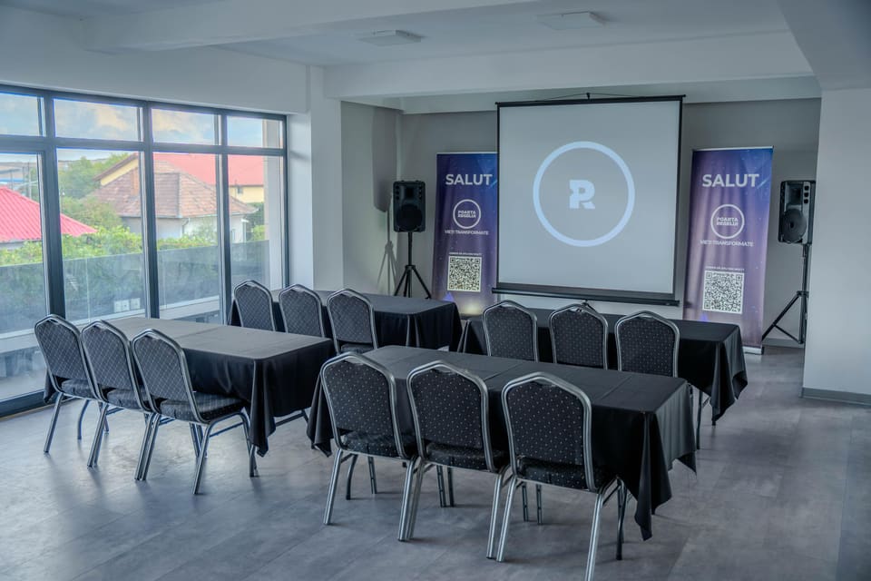 The hall in a classroom layout: tables under black cloths set in rows, with chairs facing the screen.